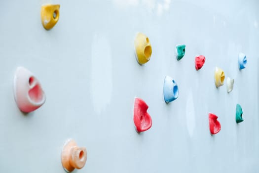 Colorful climbing holds on wall for outdoor rock climbing