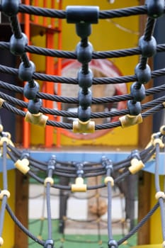 Close-up view of colorful playground rope bridge for children's outdoor recreational equipment in a public park. Ensuring safety and durability for a fun and adventurous playtime