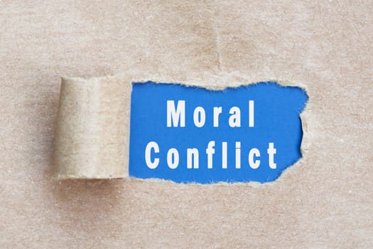 Moral conflict text on brown paper with torn hole and rolled edge.