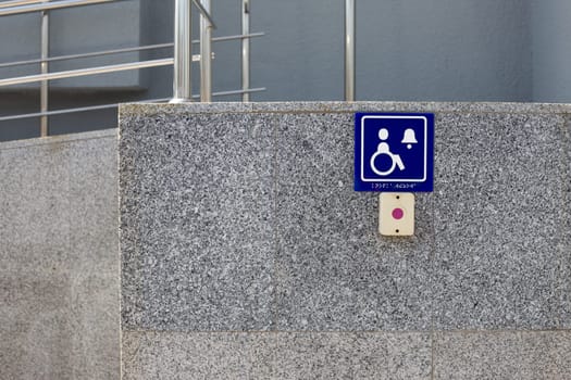 Help button for people with disabilities on the wall of building at the entrance, accessible environment for disabled people