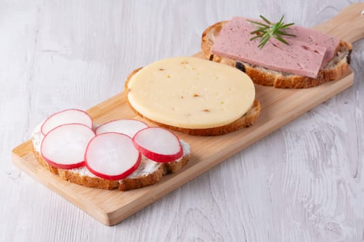 Sandwiches with radishes, cottage cheese, cheese and sausage.