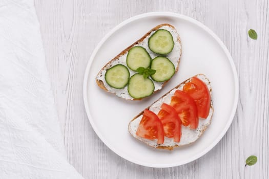 Healthy sandwiches with white cottage cheese, cucumber and tomato.