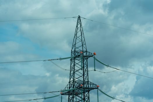 High voltage towers with sky background. Power line support with wires for electricity transmission. High voltage grid tower with wire cable at distribution station. Energy industry, energy saving.