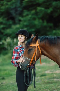 Happy blonde with horse in forest. Woman and a horse walking through the field during the day. Dressed in a plaid shirt and black leggings