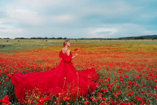 Woman poppy field red dress. Happy woman in a long red dress in a beautiful large poppy field. Blond stands with her back posing on a large field of red poppie