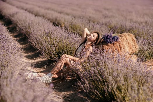 A young girl is sitting in a field of purple flowers, holding a purple flower in her hand. She is smiling and she is enjoying the moment. Concept of happiness and contentment