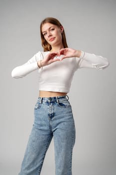 Young Woman Making Heart Shape With Hands in studio