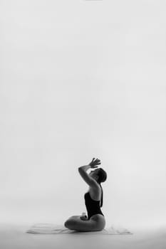 Portrait of a beautiful young woman wearing black sportswear working out in studio.