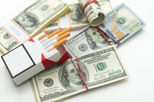 white cigarettes lying on the dollar bills. concept of financial cost of smoking. High quality photo