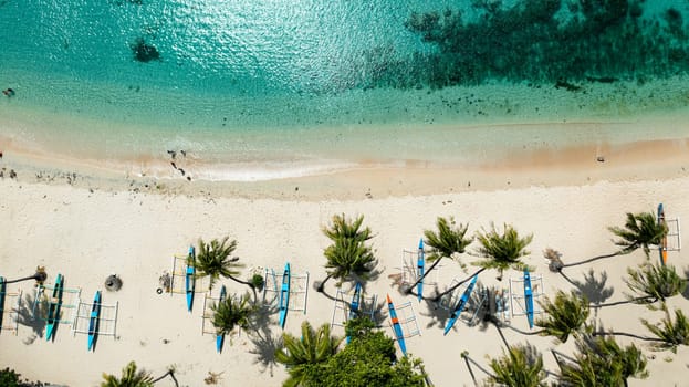 Aerial view of sandy beach with palm trees and sea surf with waves. Pagudpud, Ilocos Norte Philippines