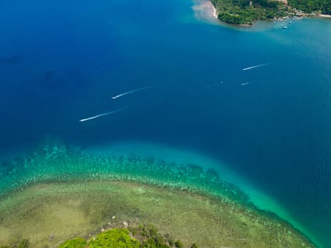 Aerial view of turquoise lagoon surface on atoll and coral reef, copy space for text. Top view transparent turquoise ocean water surface.
