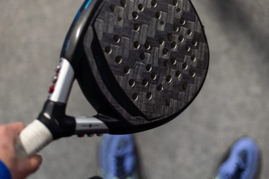 Paddle tennis: Paddel racket and ball in front of an outdoor court. High quality photo