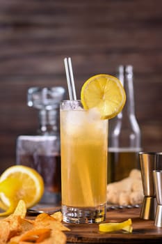 Whiskey cocktail with ginger beer, garnished with lemon 