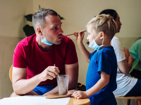 Father and son eat chocolate dessert with spoons in Cafe. Spending time together. Sweet tooth. Happy childhood.