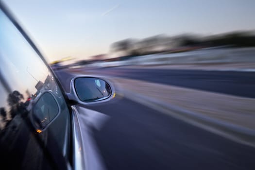 Car, mirror and moving on highway in road with speed, travel and driving fast for race or emergency. Vehicle, transport and motion blur in hurry on freeway, street and rush to work with insurance.