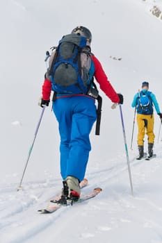 A group of professional ski mountaineers ascend a dangerous snowy peak using state-of-the-art equipment.