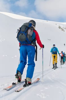 A group of professional ski mountaineers ascend a dangerous snowy peak using state-of-the-art equipment.