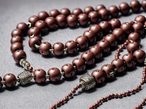 The image is a brown rosary with silver beads and a crucifix.