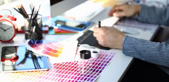 Test print paper page with colour test design fantail and magnifying glass lying at worktable for further promotion closeup