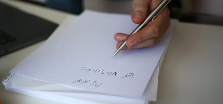 Male hand hold silver pen composing to do list for life closeup