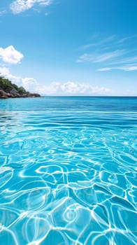 A clear blue water with a white sandy beach in the background