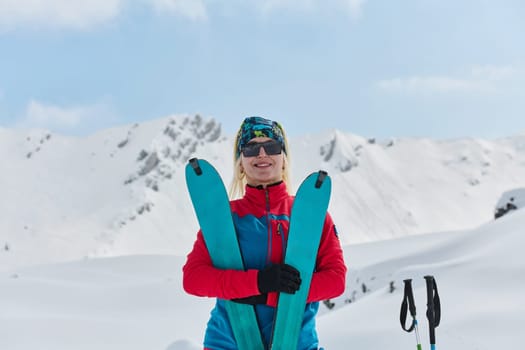 A professional woman skier rejoices after successfully climbing the snowy peaks of the Alps.