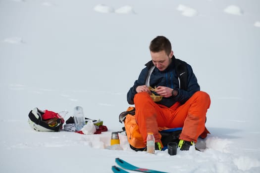 A skier pauses on a snow-capped ridge to savor a moment of peace and take in the breathtaking alpine panorama.