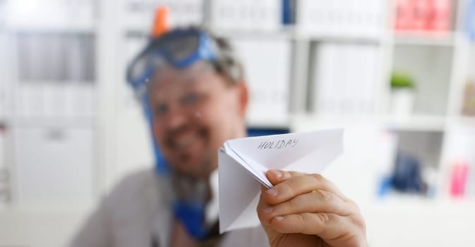 Man wearing suit and tie in goggle and snorkel play with fly papers plane in office closeup. Count days to leave annual day off workaholic freedom fun tourism resort idea ticket sale overseas concept