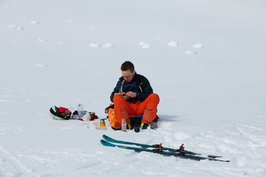 A skier pauses on a snow-capped ridge to savor a moment of peace and take in the breathtaking alpine panorama.