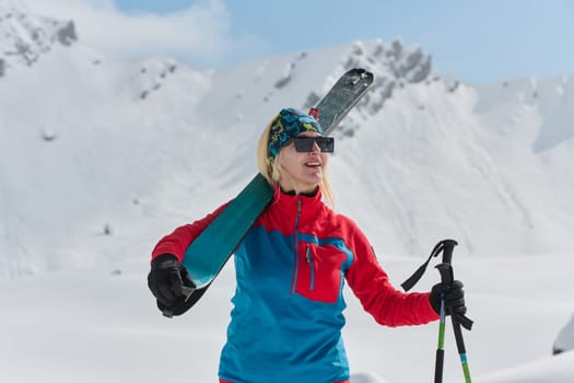 A professional woman skier rejoices after successfully climbing the snowy peaks of the Alps.