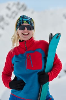 A determined skier scales a snow-capped peak in the Alps, carrying backcountry gear for an epic descent