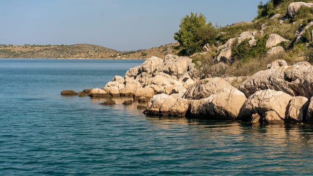 Scenic coastal view, rocky beach of Dugi Otok island in sunlight, Adriatic Sea, Croatia