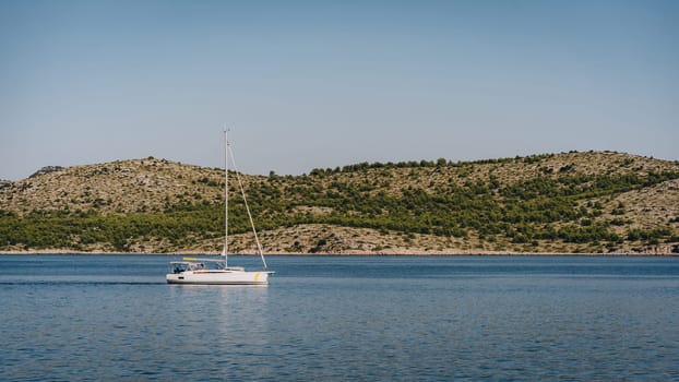 Yacht sailing along amazing scenic coast of Dugi Otok island, moment of travel in Adriatic Sea, Croatia