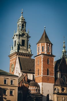 Clock and statues on stone medieval tower of Wawel Royal Castle, Krakow, Poland