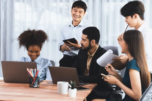 Happy diverse business people work together, discussing in corporate office. Professional and diversity teamwork discuss business plan on desk with laptop. Modern multicultural office worker. Concord