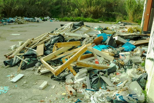 Delve into the haunting landscape of urban decay and environmental degradation with this striking image of a mountain of trash in an abandoned factory.