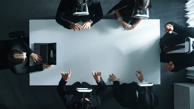 Top down aerial view of professional business team wear vr headset to enter virtual world while sitting and using hand gestures to manipulate the data from the manager laptop. Technology. Directorate.