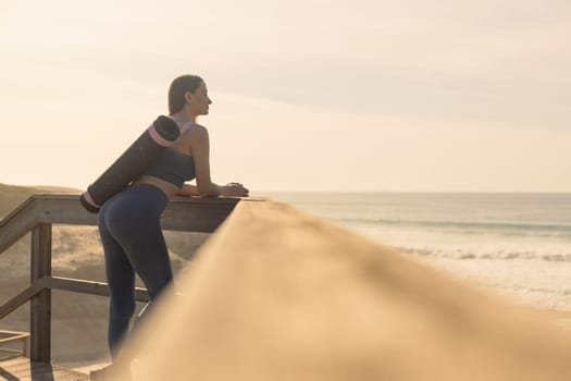 Woman practicing yoga outdoor. Beautiful girl practice asana in online class. Calmness and relax. Background with sunrise