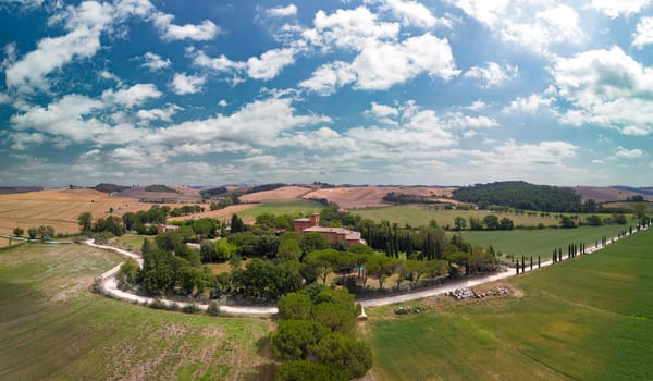 Road lined with Cypress trees leading to a farmhouse. Tuscany, Italy