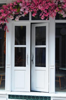 Building fixture white door adorned with pink flowers.