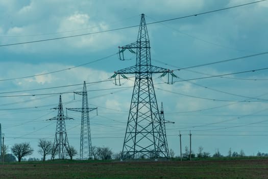 High voltage towers with sky background. Power line support with wires for electricity transmission. High voltage grid tower with wire cable at distribution station. Energy industry, energy saving.