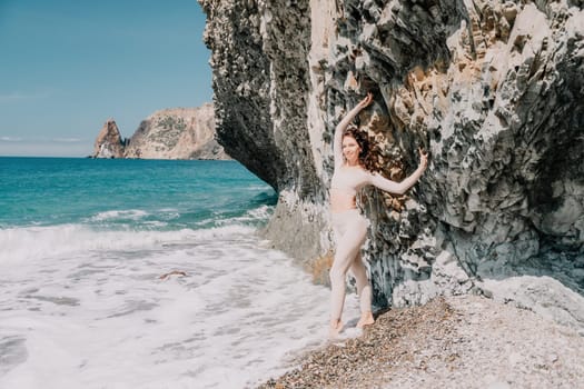 Happy young attractive brunette woman in red swimsuit, on the beach and sea background. Holiday vacation and travel concept.