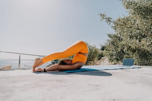 Fitness woman sea. Outdoor workout on yoga mat in park near to ocean beach. Female fitness pilates yoga routine concept. Healthy lifestyle. Happy fit woman exercising with rubber band in park.