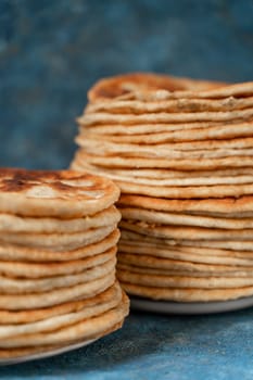 Flatbread lavash, chapati, naan, heap of tortilla on a blue background Homemade flatbread stacked