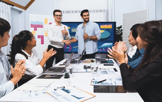 Analyst team leader shake hand with his colleague after successful data analysis meeting using FIntech software power with business intelligence or BI dashboard. Prudent