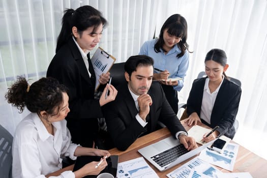 Diverse group of business analyst team analyzing financial data report paper on office table. Chart and graph dashboard by business intelligence analysis for strategic marketing planning Meticulous