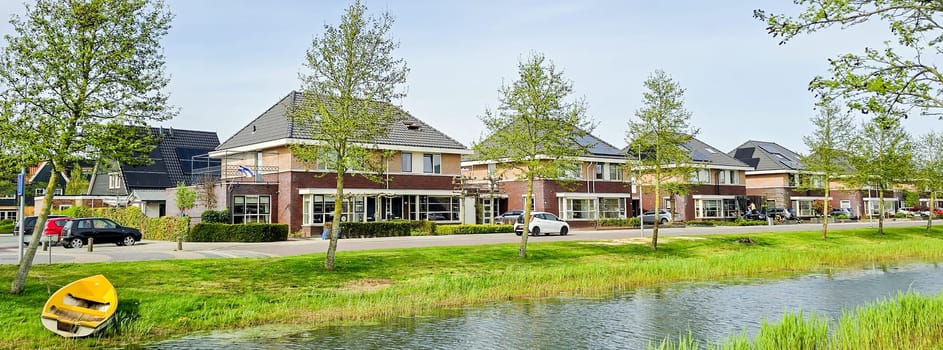 Dutch family street with modern houses with solar panels on the roof, new building with black solar panels. Zonnepanelen, Zonne energie, Translation: Solar panel, Sun Energy