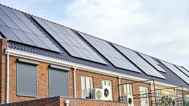 air source heat pump unit installed outdoors at a modern home with solar panels in the Netherlands, new house with black solar panels. Zonnepanelen, Zonne energie, Translation: Solar panel, Sun Energy