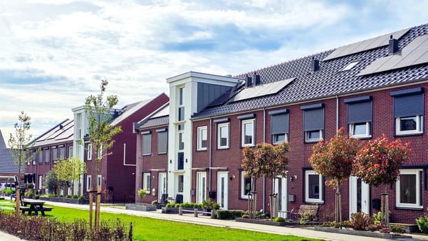 Newly built houses with black solar panels on the roof against a sunny sky, Zonnepanelen, Zonne energie, Translation: Solar panel, Sun Energy