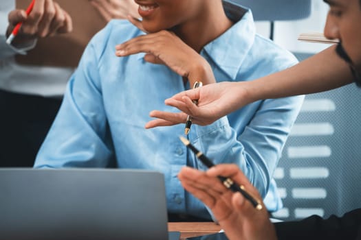 Diverse business people work together, discuss in corporate office. Professional teamwork discussing and pointing at laptop. Modern multicultural office worker. Concord